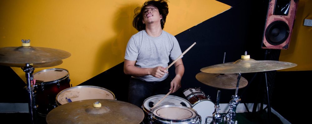 Man recording music on drum set in studio
