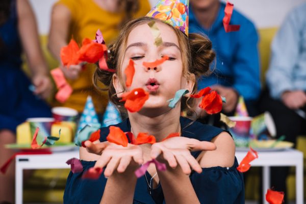 portrait-teenage-girl-blowing-confetti-her-birthday